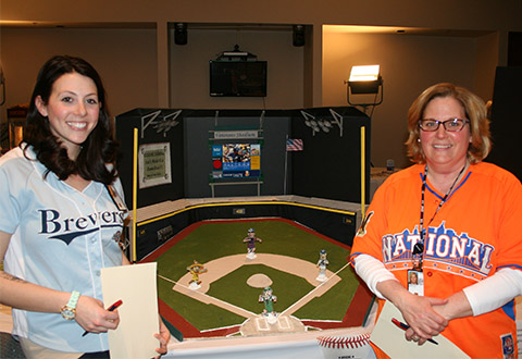 Tiffany Buckenberger, staff medical technologist and Mary Jo Dejanovich, point-of-care advanced staff specialist, stand in front of their game focused on “Communication of Critical Results.”