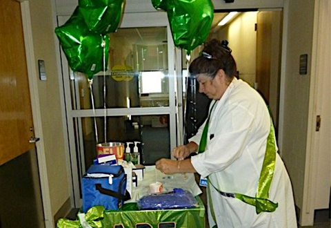 A nurse prepares flu shots using a mobile cart so that vacine can be brought to staff in hospital units.