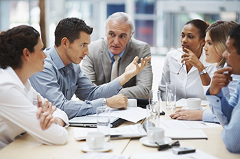 Professionals diiscussing an issue as the sit across a table. 