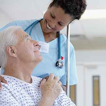 Nurse speaking with a seated patient. 