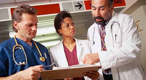 Three clinicians review a patient's chart.